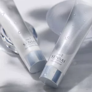 Silky Purifying Cleansing Cream and Creamy Soap bottles shown next to each other in lifestyle setting with mood lighting